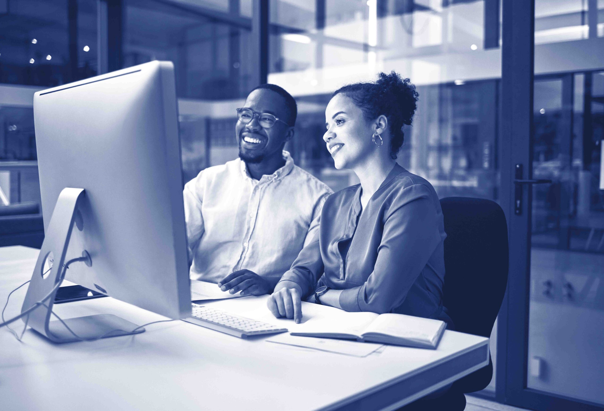 Night meeting, internet business and employees talking about web design on a computer in a dark office at night. African workers happy on company website and working overtime for partnership